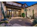 Inviting courtyard showcasing desert landscaping with large cacti, pavers and custom iron lighting at 10057 E Blue Sky Dr, Scottsdale, AZ 85262