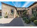 Stunning front yard with desert landscaping, brick pathway, and stucco exterior at 10057 E Blue Sky Dr, Scottsdale, AZ 85262