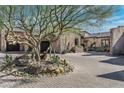 Beautiful front yard with mature tree and circular driveway leading to the garage at 10057 E Blue Sky Dr, Scottsdale, AZ 85262