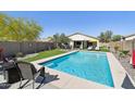 Inviting backyard oasis with a sparkling pool, artificial turf, and lounge chairs for ultimate relaxation at 10224 S 175Th Ave, Goodyear, AZ 85338