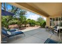 Relaxing covered patio with lounge chairs and outdoor seating overlooking the backyard at 12738 W Nogales Dr, Sun City West, AZ 85375