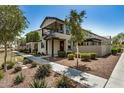 Inviting home featuring manicured landscaping, a charming porch, and a welcoming walkway at 1635 N 208Th Ave, Buckeye, AZ 85396