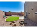 Backyard features desert landscaping, a small patch of grass, and a cute stone firepit at 17606 N 17Th Pl # 1054, Phoenix, AZ 85022