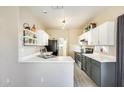 Galley kitchen featuring white cabinets, updated countertops, and stainless steel appliances at 17606 N 17Th Pl # 1054, Phoenix, AZ 85022