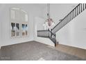 Bright landing area with high ceilings, staircase, and large windows, providing ample natural light at 18525 N Larkspur Dr, Maricopa, AZ 85138