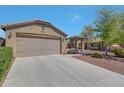 Side view of home, highlighting the attached two car garage, desert landscaping, and covered front porch at 18590 W Vogel Ave, Goodyear, AZ 85338