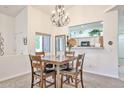 Open-concept dining area with a wooden table set, chandelier, and an opening looking into the kitchen at 18650 N 91St Ave # 3701, Peoria, AZ 85382