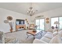Bright living room featuring a neutral color palette, decorative chandelier, and sliding doors to the backyard at 18650 N 91St Ave # 3701, Peoria, AZ 85382