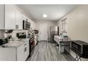 Modern kitchen features white cabinetry, stainless steel appliances, and stylish gray flooring at 2221 E Lynne Ln, Phoenix, AZ 85042