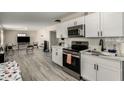 Bright kitchen boasts white cabinetry, stainless steel appliances, and sleek, modern finishes at 2221 E Lynne Ln, Phoenix, AZ 85042
