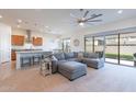 Bright and airy living room featuring a large gray sectional sofa and sliding glass doors to the backyard at 23038 E Twilight Dr, Queen Creek, AZ 85142