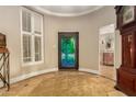 Elegant foyer featuring a colorful leaded glass front door, tiled floors, and natural light from the window at 3006 N Manor W Dr, Phoenix, AZ 85014