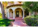 Inviting covered front porch with white columns and detailed wrought iron door offers classic elegance at 3006 N Manor W Dr, Phoenix, AZ 85014