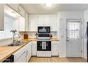 Bright kitchen with white cabinets, butcher block countertops and stainless-steel sink with a door to the backyard at 3306 W Lupine Ave, Phoenix, AZ 85029