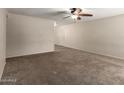 Neutral living room with carpet flooring, ceiling fan, and white trim at 3732 E Greenway Ln, Phoenix, AZ 85032