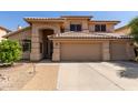 Charming two-story home featuring a tile roof, arched entryway, and a spacious three car garage at 5215 W Del Rio St, Chandler, AZ 85226