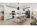 Modern kitchen with white cabinets, quartz countertops, and a stylish island with seating at 5616 S Caisson Way, Mesa, AZ 85212