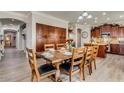 Open-concept dining area with wood floors, adjacent to a modern kitchen and cozy living area at 6528 W Brookhart Way, Phoenix, AZ 85083