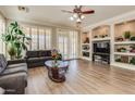Inviting living room with wood flooring, built-in shelving, and large windows with plantation shutters at 6528 W Brookhart Way, Phoenix, AZ 85083