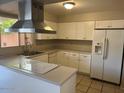 Bright kitchen with white cabinets, stainless steel hood, and modern appliances at 6624 S Granada Dr, Tempe, AZ 85283