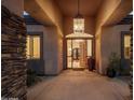 Grand entryway with stone accents, pendant lighting, and a glimpse of the home's interior at 9417 E Charter Oak Dr, Scottsdale, AZ 85260