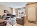 Bright living room boasts a cozy fireplace, a sliding glass door, and neutral tones at 9708 E Via Linda -- # 1338, Scottsdale, AZ 85258