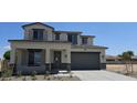 View of the home featuring neutral colors, a covered porch, and a two-car garage with a desert landscape at 19117 W Missouri Ave, Litchfield Park, AZ 85340