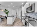 Modern kitchen featuring white cabinets, stainless steel appliances, and an island with a dark countertop at 2511 W Queen Creek Rd # 474, Chandler, AZ 85248