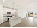 Modern kitchen with white cabinetry, stainless steel appliances, a granite island, and an open floor plan at 2680 E Santa Rosalia Dr, Casa Grande, AZ 85194