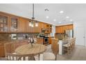 Well-appointed kitchen featuring granite countertops, wood cabinetry, and a breakfast nook at 26808 N 64Th Ln, Phoenix, AZ 85083