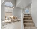 Open-concept dining room with stairs and a large window, showcasing natural light and space at 4422 E Dry Creek Rd, Phoenix, AZ 85044