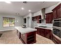 A spacious kitchen with cherry wood cabinets, an island, stainless steel appliances, and tile backsplash at 702 E Capricorn Way, Chandler, AZ 85249