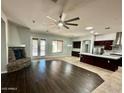 An open-concept living area showcases a stone fireplace, ceiling fan and seamless flow into the well-appointed kitchen at 702 E Capricorn Way, Chandler, AZ 85249