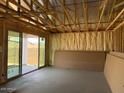 Living room in new construction home has exposed beams and sliding glass doors to the backyard at 7700 W Saddlehorn Rd, Peoria, AZ 85383