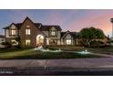 Charming two-story Tudor-style home featuring a brick facade and well-manicured lawn with accent lighting at 908 N Creston --, Mesa, AZ 85213