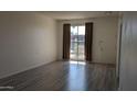 Spacious living room with wood-look floors, large window, and neutral paint at 10039 W Lancaster Dr, Sun City, AZ 85351