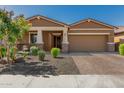 Well-maintained house showcasing a neat yard, brick driveway, and inviting covered porch with stone pillars at 12143 W Marguerite Ave, Avondale, AZ 85323
