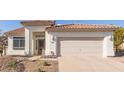 Home featuring a tile roof, a two-car garage, and desert landscaping, as well as decorative front door at 1226 E Presidio Rd, Phoenix, AZ 85022