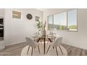 Bright dining area with a modern glass table and stylish seating, perfect for intimate meals at 13618 W Phacelia Ln, Peoria, AZ 85383