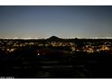 Nighttime view of city lights and a distant desert mountain at 15025 E Scarlet Sky Ln # 1, Fountain Hills, AZ 85268