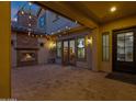 Cozy outdoor patio with a brick fireplace and string lights at 17937 E Colt Ct, Queen Creek, AZ 85142