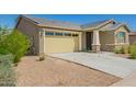 Attached two-car garage featuring paneled windows, desert landscaping, and a wide driveway at 2464 N Morrison Ave, Casa Grande, AZ 85122
