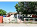 Charming single-story home featuring a secure white fence and mature landscaping at 2614 W Greenway Rd, Tempe, AZ 85282