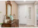 Inviting entryway with a decorative mirror, wooden table, neutral paint, and a white front door at 2731 E Cherry Hill Dr, Gilbert, AZ 85298