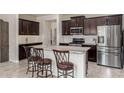 Modern kitchen features a large island with seating, stainless steel appliances, and dark wood cabinets at 2731 E Cherry Hill Dr, Gilbert, AZ 85298