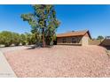 A charming single-story home, with arched windows and low-maintenance landscaping and a mature shade tree at 3124 W Taro Ln, Phoenix, AZ 85027