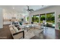 Open-concept living room with a plush sofa, hardwood floors, and sliding doors to the backyard at 3229 E Campbell Ave, Phoenix, AZ 85018