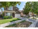 Two-story home featuring green exterior, red shutters, a well-kept lawn and long driveway at 4337 E Vaughn Ave, Gilbert, AZ 85234