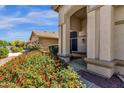 Close up of the front entrance of a beige home with colorful flowers at 4633 E Desert Cactus St, Phoenix, AZ 85032
