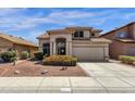 Inviting beige home featuring a tile roof, landscaped front yard, and a two-car garage at 4633 E Desert Cactus St, Phoenix, AZ 85032